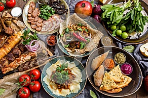 Outdoors Food Concept. Appetizing barbecued steak, sausages and grilled vegetables on a wooden picnic table.