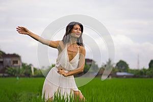 Outdoors holidays portrait of attractive and happy middle aged Asian Chinese woman in white dress enjoying freedom and nature at