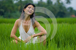 Outdoors holidays portrait of attractive and happy middle aged Asian Chinese woman in white dress enjoying freedom and nature at