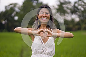 Outdoors holidays portrait of attractive and happy middle aged Asian Chinese woman in white dress enjoying freedom and nature