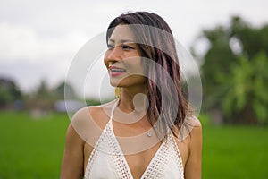 Outdoors holidays portrait of attractive and happy middle aged Asian Chinese woman in white dress enjoying freedom and nature at