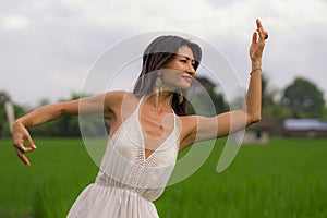 Outdoors holidays portrait of attractive and happy middle aged Asian Korean woman in white dress enjoying freedom and nature at