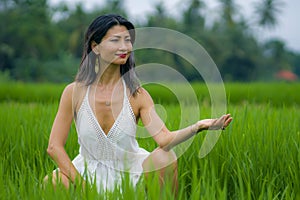 Outdoors holidays portrait of attractive and happy middle aged Asian Korean woman in white dress enjoying freedom and nature at