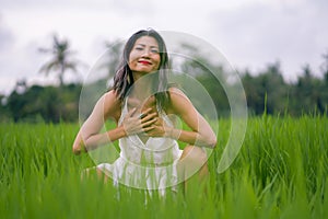 Outdoors holidays portrait of attractive and happy middle aged Asian Korean woman in white dress enjoying freedom and nature at