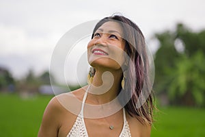 Outdoors holidays portrait of attractive and happy middle aged Asian Korean woman in white dress enjoying freedom and nature at