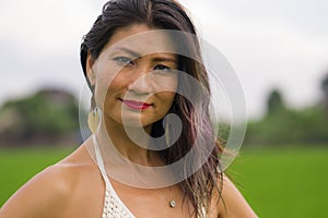 Outdoors holidays portrait of attractive and happy middle aged Asian Korean woman in white dress enjoying freedom and nature at