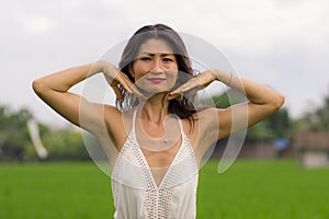 Outdoors holidays portrait of attractive and happy middle aged Asian Korean woman in white dress enjoying freedom and nature at