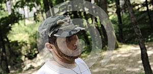 Outdoors horizontal portrait of happy hiker young man with red beard, feel good after hiking in forest. Traveler bearded male