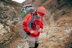Outdoors image of  extreme hiker man hiking in mountains with travel backpack.