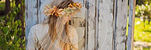 Outdoors lifestyle close up portrait of charming blonde young woman wearing a wreath of autumn leaves. Wearing stylish