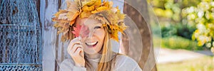 Outdoors lifestyle close up portrait of charming blonde young woman wearing a wreath of autumn leaves. Wearing stylish