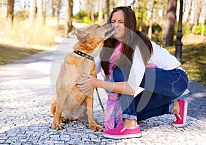 Outdoors lifestyle portrait of beautiful girl with a cute dog on