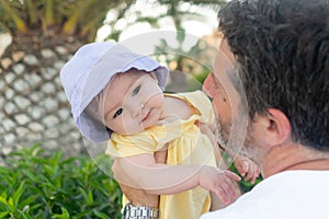 outdoors lifestyle portrait of father and little daughter - man holding his adorable and happy baby girl in front of the see