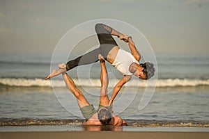 Outdoors lifestyle portrait young attractive and concentrated couple of yoga acrobats practicing acroyoga balance and meditation
