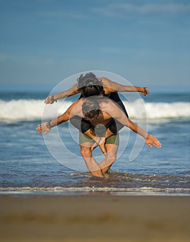 Outdoors lifestyle portrait young attractive and concentrated couple of yoga acrobats practicing acroyoga balance and meditation