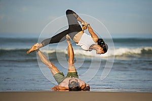 Outdoors lifestyle portrait young attractive and concentrated couple of yoga acrobats practicing acroyoga balance and meditation