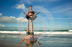 Outdoors lifestyle portrait young attractive and concentrated couple of yoga acrobats practicing acroyoga balance and meditation