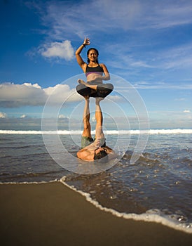 Outdoors lifestyle portrait young attractive and concentrated couple of yoga acrobats practicing acroyoga balance and meditation