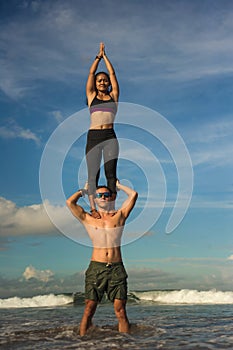 Outdoors lifestyle portrait young attractive and concentrated couple of yoga acrobats practicing acroyoga balance and meditation