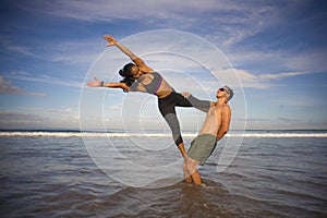 Outdoors lifestyle portrait young attractive and concentrated couple of yoga acrobats practicing acroyoga balance and meditation