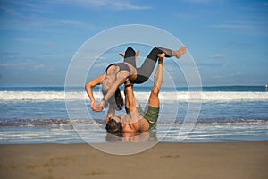 Outdoors lifestyle portrait young attractive and concentrated couple of yoga acrobats practicing acroyoga balance and meditation