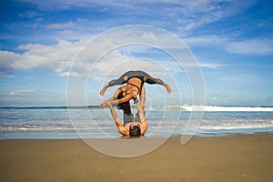 Outdoors lifestyle portrait young attractive and concentrated couple of yoga acrobats practicing acroyoga balance and meditation