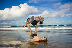 Outdoors lifestyle portrait young attractive and concentrated couple of yoga acrobats practicing acroyoga balance and meditation