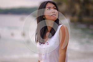 Outdoors lifestyle portrait of young beautiful and happy Asian Chinese woman in Summer dress enjoying cheerful walk at tropical