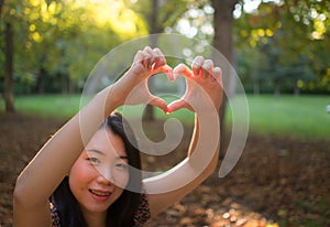 Outdoors lifestyle portrait of young happy and beautiful Asian Korean woman enjoying relaxed and cheerful at city park in Autumn