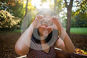 Outdoors lifestyle portrait of young happy and beautiful Asian Korean woman enjoying relaxed and cheerful at city park in Autumn