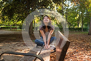 Outdoors lifestyle portrait of young happy and beautiful Asian Korean woman enjoying relaxed and cheerful at sitting on city park