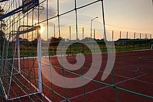 Outdoors mini football and basketball court with ball gate and basket surrounded with high protective fence