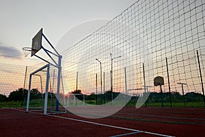 Outdoors mini football and basketball court with ball gate and basket surrounded with high protective fence