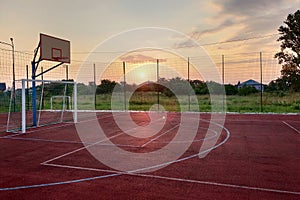 Outdoors mini football and basketball court with ball gate and basket surrounded with high protective fence