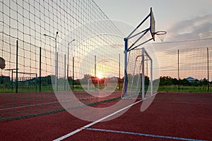 Outdoors mini football and basketball court with ball gate and basket surrounded with high protective fence