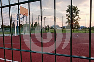 Outdoors mini football and basketball court with ball gate and basket surrounded with high protective fence