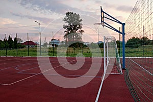 Outdoors mini football and basketball court with ball gate and basket surrounded with high protective fence