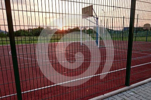 Outdoors mini football and basketball court with ball gate and basket surrounded with high protective fence