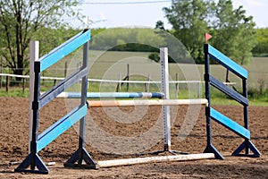 Outdoors photo of wooden barriers for jumping horses. Preparation of horses for performance on equestrian training