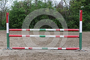 Outdoors photo of wooden barriers for jumping horses. Preparation of horses for performance on equestrian training