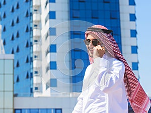 Outdoors portrait of an arabian man talking on a cell ph