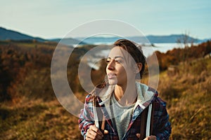 Outdoors portrait backpacker woman relaxing in nature during hiking by mountains range