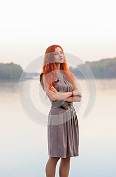 Outdoors portrait of beautiful confident woman with red hair, co