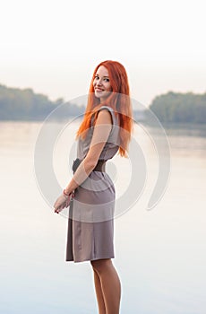 Outdoors portrait of beautiful smiling woman with red hair, colo