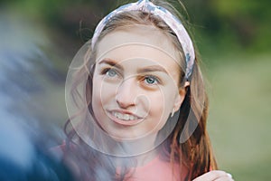 Outdoors portrait of beautiful young brunette woman. Face young beautiful girl closeups short hair summer park smiling.