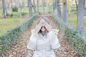 Outdoors portrait of a beautiful young Woman covering her eyes a