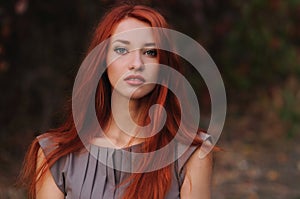 Outdoors portrait of beautiful young woman with red hair