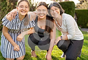 Outdoors portrait of daughter, mother and grandmother having fun in their garden.