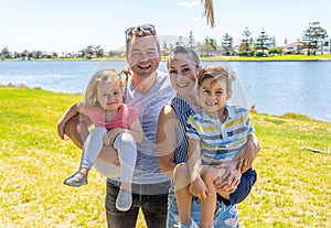 Outdoors Portrait of happy caucasian family of mum dad, boy and little girl having fun in the park