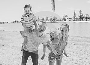 Outdoors Portrait of happy caucasian family of mum dad, boy and little girl having fun in the park